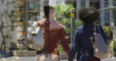Animation of bokeh over diverse couple walking and holding hands, slow motion. Valentine's day and love concept digitally generated video.