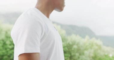 Slow motion video of african american man wearing white t-shirt with copy space. Fashion, design and colour concept.