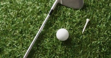 Close up of golf club and ball on grass, copy space, slow motion. Golf, sport and hobby concept.