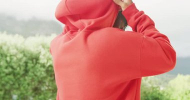 Slow motion video of african american man wearing red hoodie with copy space. Fashion, design and colour concept.