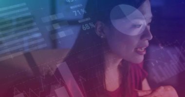 Animation of data processing over biracial businesswoman working in office. Global business, finances, computing and data processing concept digitally generated video.