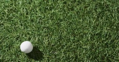 Close up of golf ball on grass, copy space, slow motion. Golf, sport and hobby concept.