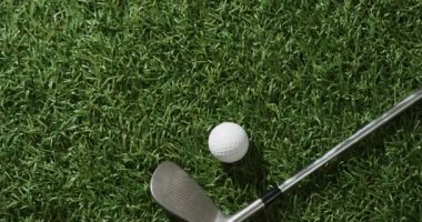 Close up of golf club and ball on grass, copy space, slow motion. Golf, sport and hobby concept.