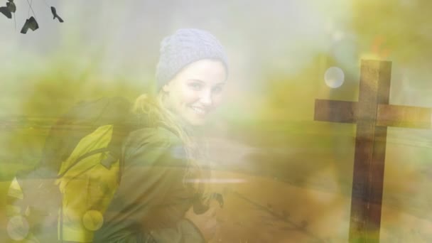 バックパックと公園で明るい太陽に対して横断笑みを浮かべて白人の若い女性のアニメーション デジタル複合体 複数の露出 ハイキング カトリック — ストック動画