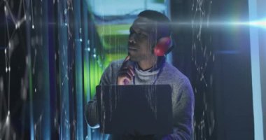 Animation of data processing over african american male it engineer and computer servers. Global computing and data processing concept digitally generated video.