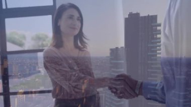 Animation of business people shaking hands over cityscape. Global business, finances, computing and data processing concept digitally generated video.