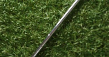 Close up of golf club and ball on grass, copy space, slow motion. Golf, sport and hobby concept.