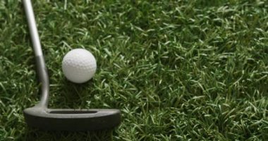 Close up of golf club and balls on grass, copy space, slow motion. Golf, sport and hobby concept.