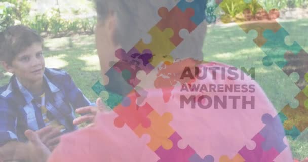 教師と話す白人の少年についてのパズルと自閉症の意識の月のテキストのアニメーション 自動認識の月 お祝いとデジタルインターフェイスのコンセプトデジタル生成されたビデオ — ストック動画