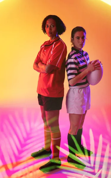 Multiracial Female Rugby Rivals Standing Back Back Illuminated Plants Abstract — Zdjęcie stockowe