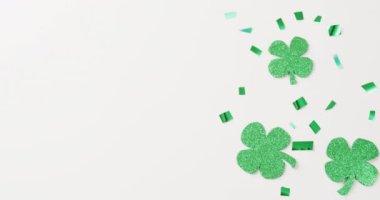 Video of st patrick's shamrock leaves and present with copy space on white background. St patrick's day, irish tradition and celebration concept.