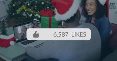 Animation of media icon over african american couple having christmas video call. Global business, pandemic and digital interface concept digitally generated video.