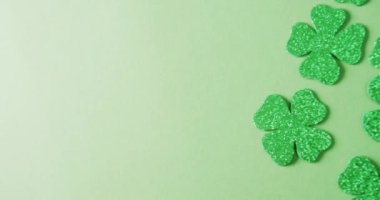 Video of st patrick's green shamrock leaves with copy space on green background. St patrick's day, irish tradition and celebration concept.