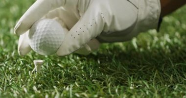 Close up of hand with glove holding golf ball on grass, copy space, slow motion. Golf, sport and hobby concept.
