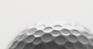 Close up of golf ball on white background, copy space, slow motion. Golf, sport and hobby concept.