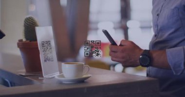 Akıllı telefon kullanarak, çift ırklı iş adamının QR kodunun animasyonu. Küresel iş ve dijital arayüz kavramı dijital olarak oluşturulmuş video.