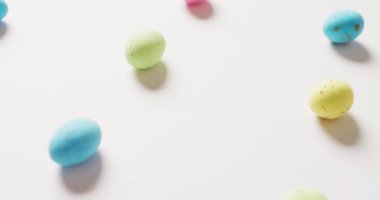 Close up of multiple colorful easter eggs on white background. Easter, tradition and celebration concept.