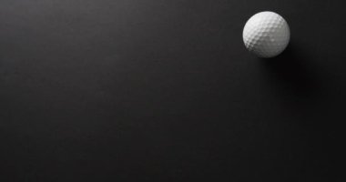 Close up of golf ball on black background, copy space, slow motion. Golf, sport and hobby concept.