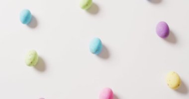 Close up of multiple colorful easter eggs on white background. Easter, tradition and celebration concept.