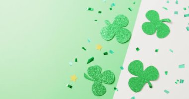 Video of st patrick's green shamrock leaves with copy space on green to white background. St patrick's day, irish tradition and celebration concept.