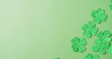 Video of st patrick's green shamrock leaves with copy space on green background. St patrick's day, irish tradition and celebration concept.
