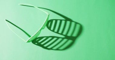 Video of st patrick's green glasses with copy space on green background. St patrick's day, irish tradition and celebration concept.