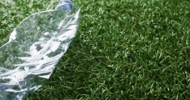Close up of plastic bottle trash on grass background, with copy space. Global recycling, ecology and nature concept.