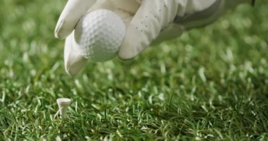 Close up of hand with glove holding golf ball on grass, copy space, slow motion. Golf, sport and hobby concept.