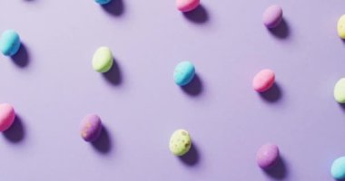 Close up of multiple colorful easter eggs on purple background. Easter, tradition and celebration concept.