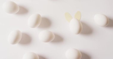 Multiple white easter eggs with rabbit ears on white background. Easter, tradition and celebration concept.