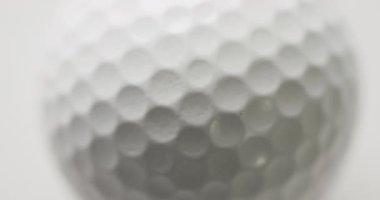 Close up of golf ball on white background, slow motion. Golf, sport and hobby concept.