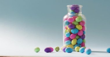 Vase with colorful easter eggs on green background with copy space. Easter, tradition and celebration concept.