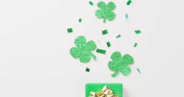 Video of st patrick's shamrock leaves and present with copy space on white background. St patrick's day, irish tradition and celebration concept.