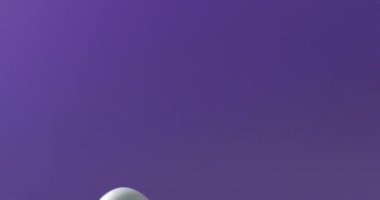 Blue easter egg with hay on purple background with copy space. Easter, tradition and celebration concept.