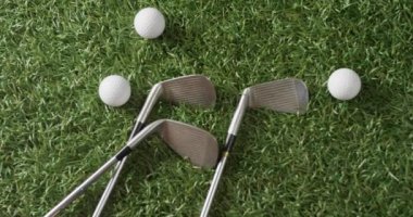 Close up of golf clubs and balls on grass, copy space, slow motion. Golf, sport and hobby concept.