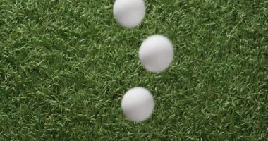 Close up of golf balls on grass, copy space, slow motion. Golf, sport and hobby concept.