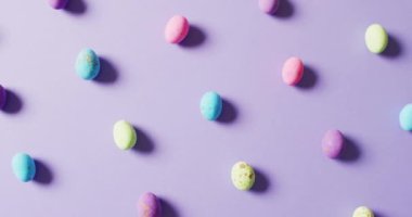 Close up of multiple colorful easter eggs on purple background. Easter, tradition and celebration concept.