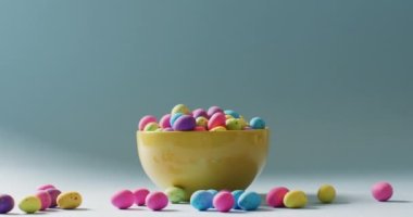 Bowl with colorful easter eggs on green background with copy space. Easter, tradition and celebration concept.
