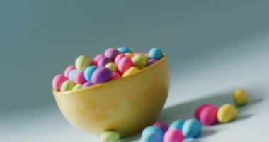 Bowl with colorful easter eggs on green background with copy space. Easter, tradition and celebration concept.