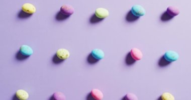 Close up of multiple colorful easter eggs on purple background. Easter, tradition and celebration concept.