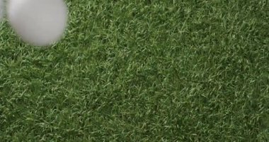 Close up of golf balls on grass, copy space, slow motion. Golf, sport and hobby concept.