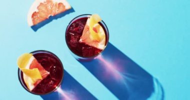 Close up of drinks with grapefruit over blue background. Cocktail day, party and celebration concept.