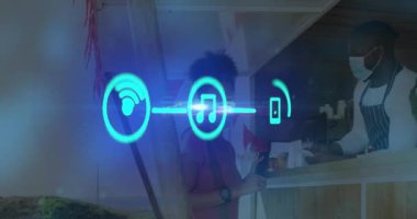 Animation of media icons over african american woman with face masks in cafe. Global business, pandemic and digital interface concept digitally generated video.