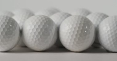 Close up of golf balls on white background, copy space, slow motion. Golf, sport and hobby concept.