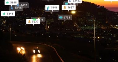 Animation of icons with counters over time-lapse of vehicles moving on street in illuminated city. Digital composite, notification, building, gps, like, social media, message, technology, night.