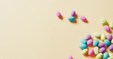 Multiple colorful easter eggs on yellow background with copy space. Easter, tradition and celebration concept.