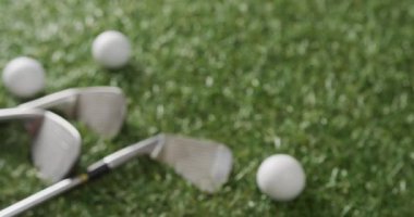 Close up of golf clubs and balls on grass, copy space, slow motion. Golf, sport and hobby concept.