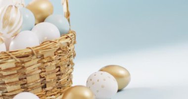 Basket with colorful easter eggs on blue background with copy space. Easter, tradition and celebration concept.
