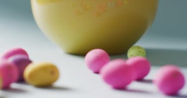 Close up bowl with colorful easter eggs on green background. Easter, tradition and celebration concept.