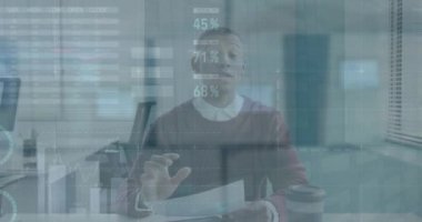 Animation of financial data processing over african american businessman having video call at office. Global business, finances and digital interface concept, digitally generated video.